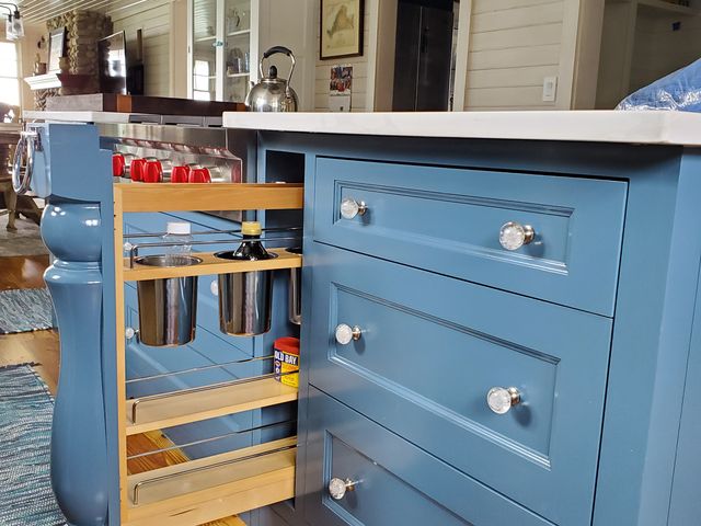 Blue kitchen island with a pull-out cabinet