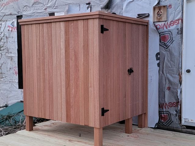 Wood enclosure with a door on a new deck