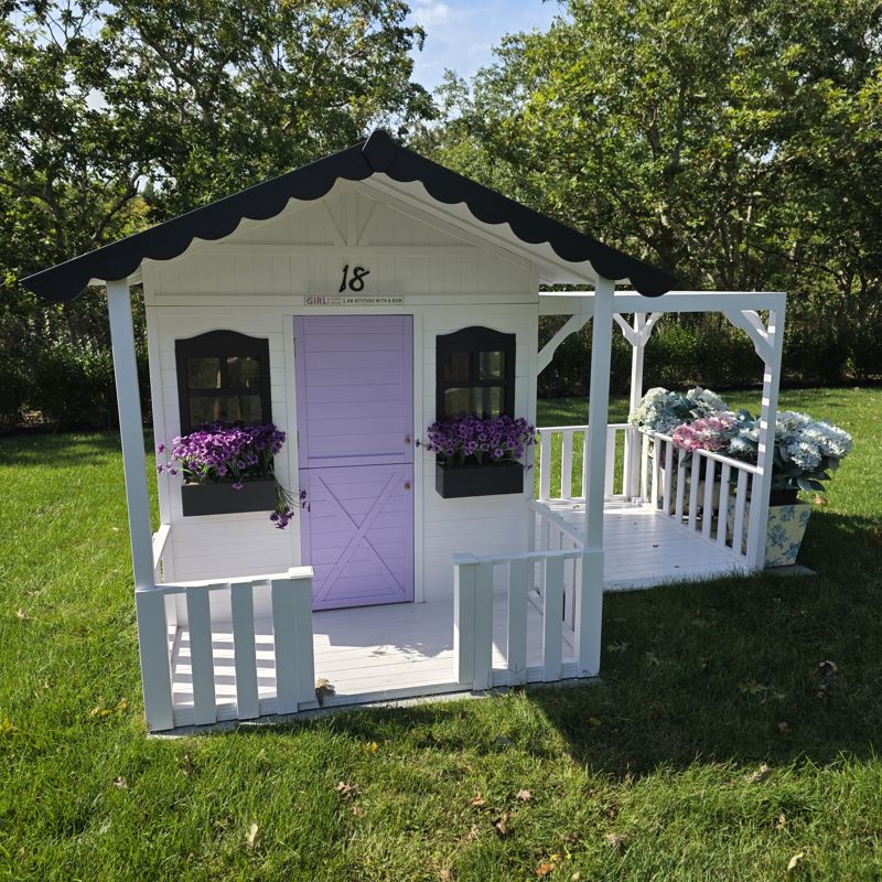 Front of the playhouse with scalloped roof trim and flower boxes