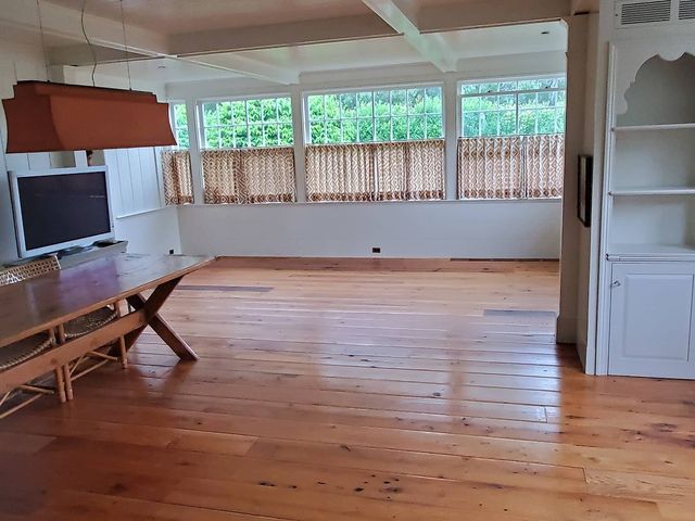 Room with wood floors and a wall of windows