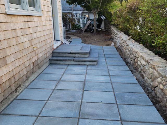 Bluestone patio next to a stone wall