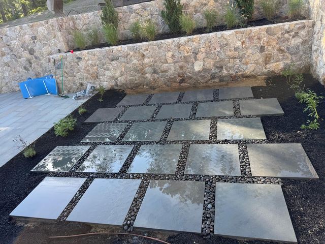 Square bluestone pavers with gravel joints below fieldstone walls