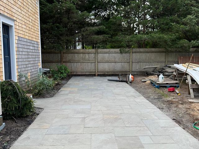 Bluestone patio along the side of a shingled house