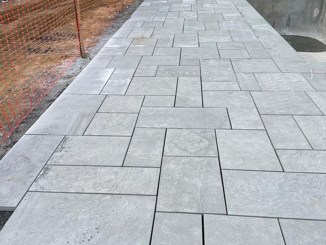 Bluestone pavers being set around a pool