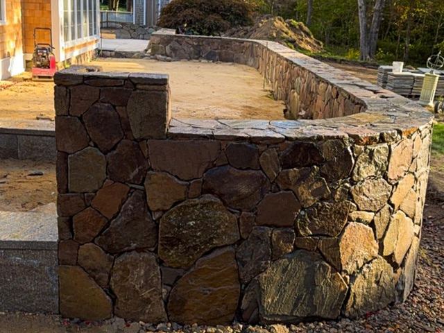 Fieldstone wall next to a house