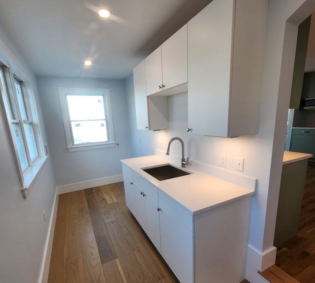 Pantry with white built-in cabinets and sink