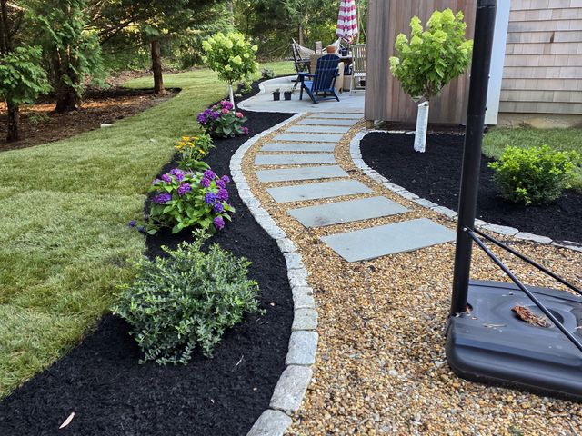 Stone path and planting beds by the house