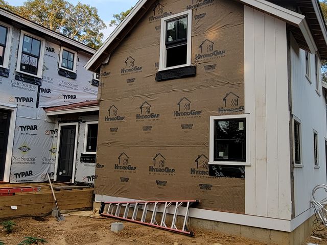 Two-story house during siding work