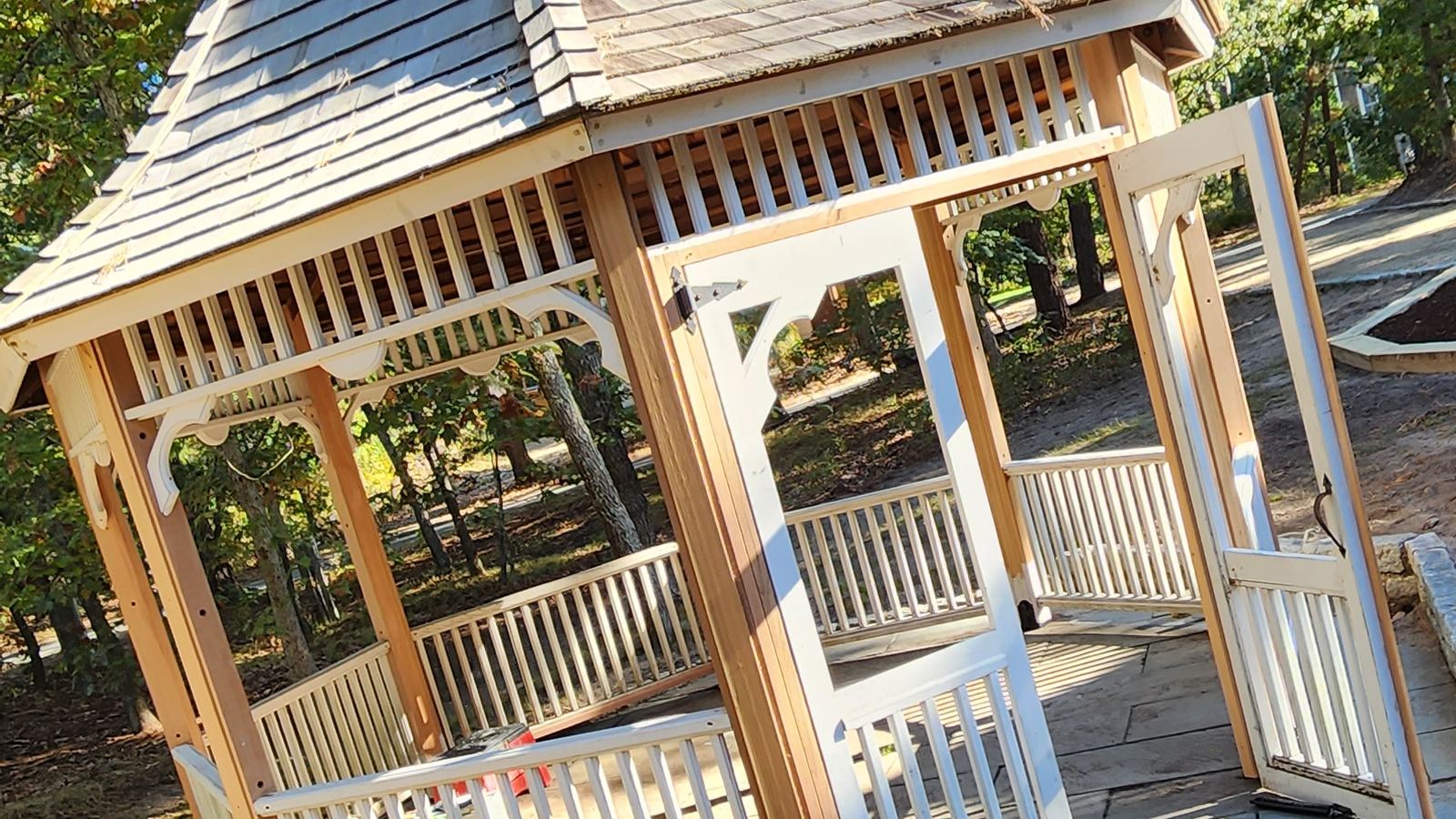 Gazebo with a shingled roof and railings