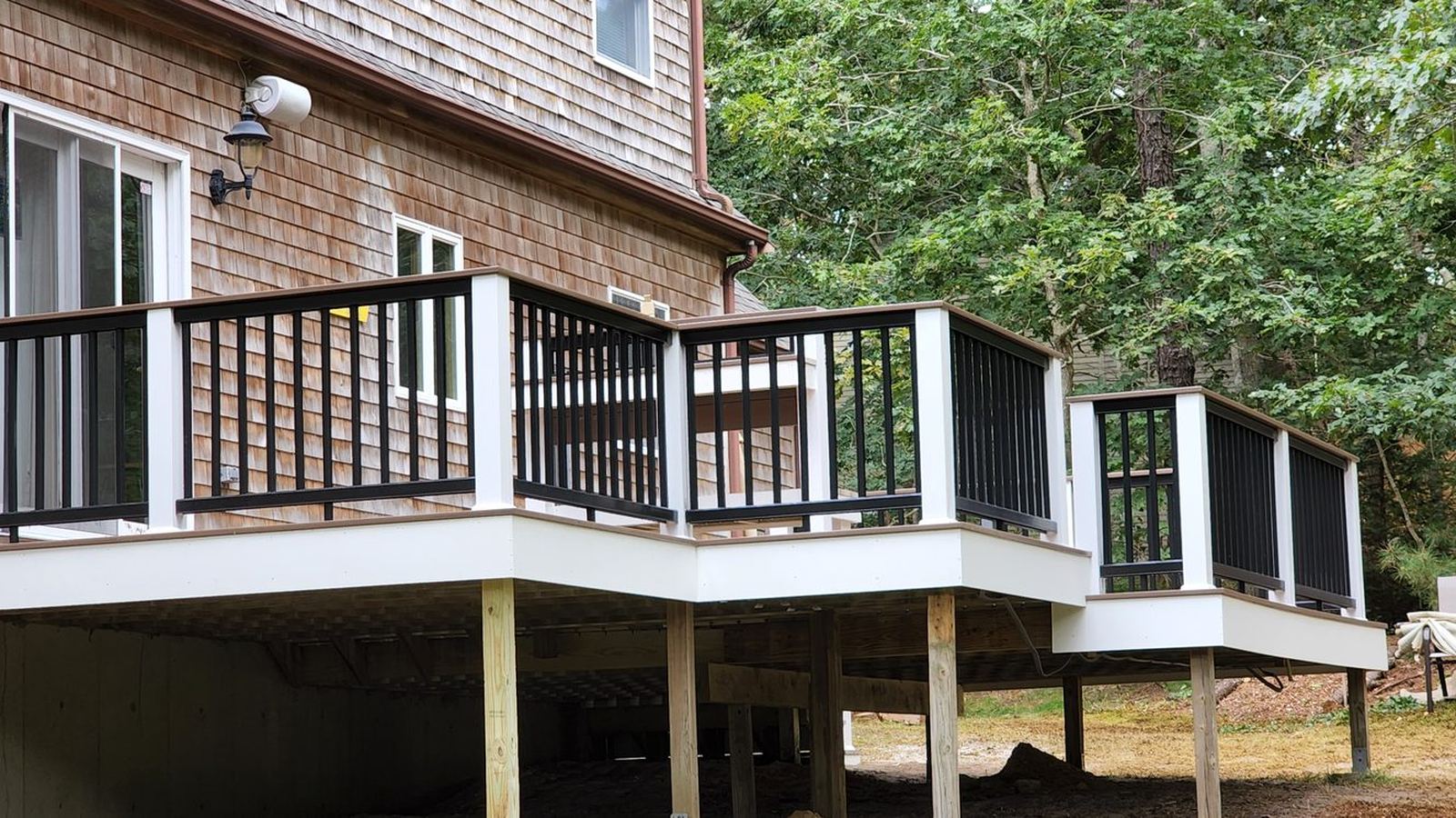Deck with black railings along a shingled house