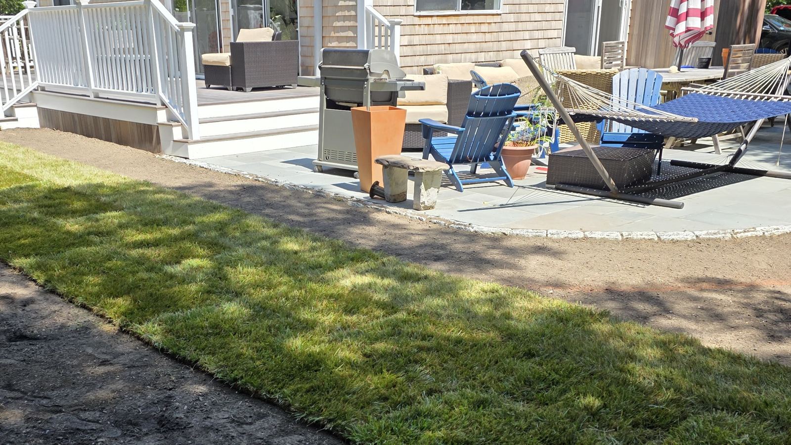 Fresh sod laid next to a patio and deck